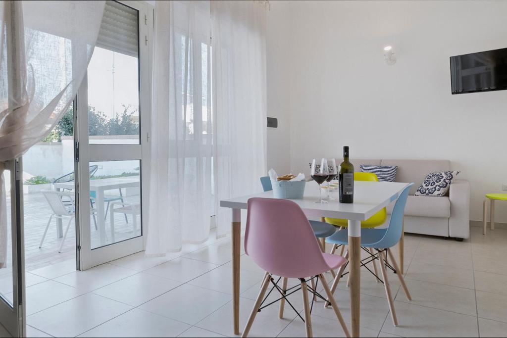 uma sala de jantar branca com uma mesa e cadeiras em Casa Te Mare em Torre Suda