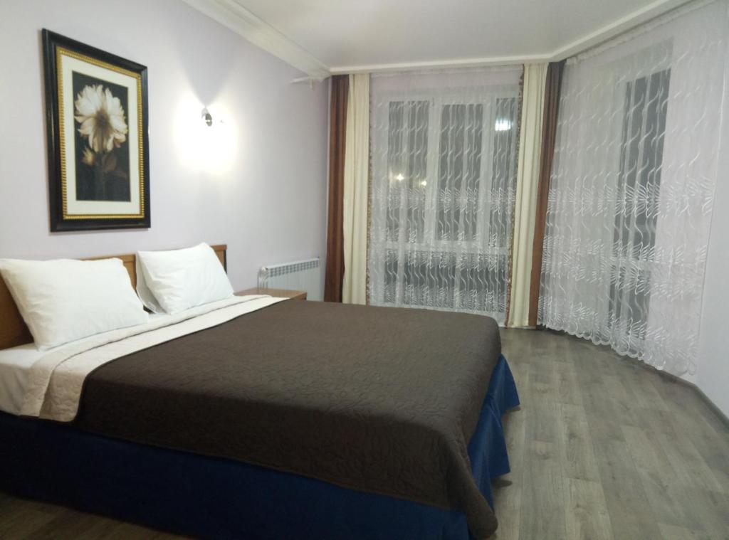 um quarto com uma cama grande e uma janela em SKY&KTS Apartments em Boryspil