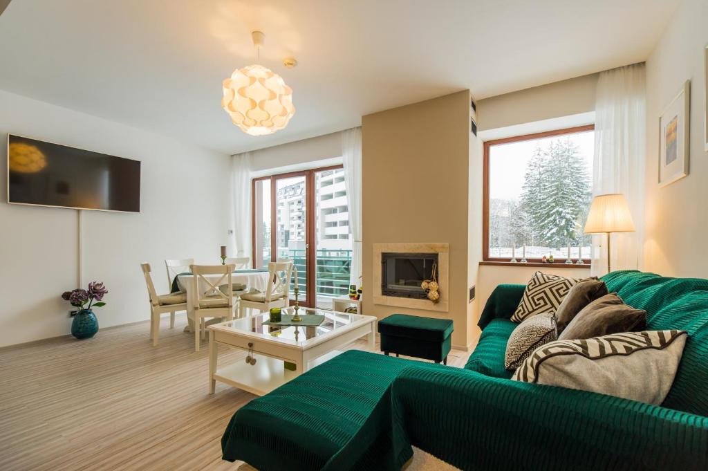 uma sala de estar com um sofá e uma mesa em Charming 2-Bedroom, Silver Mountain, A Building em Poiana Brasov