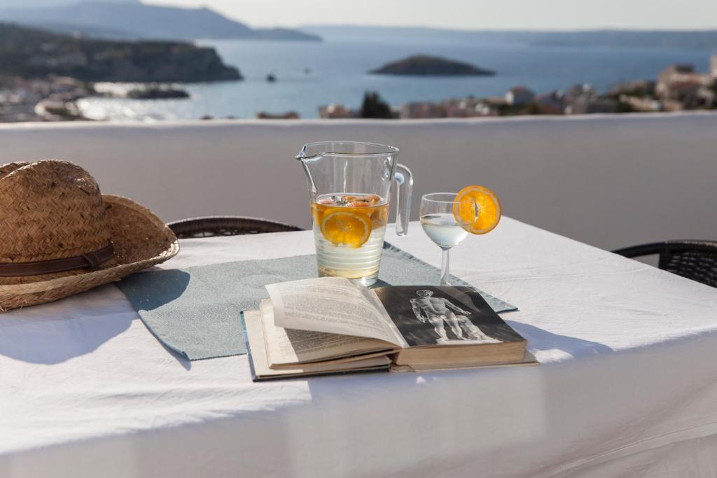 een tafel met een boek en een glas sinaasappelsap bij 7 Olives Apartments in Almirida