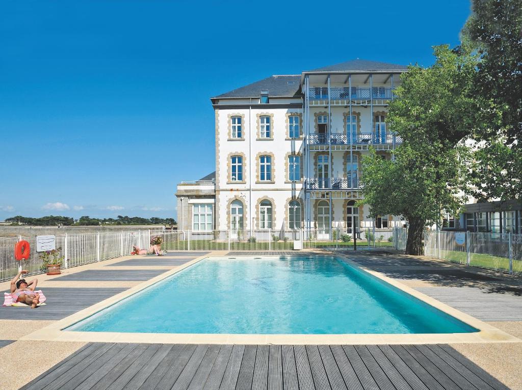 a large swimming pool in front of a building at Residence Saint Goustan - maeva Home in Le Croisic