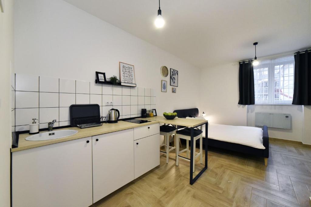 een keuken met een wastafel en een bed in een kamer bij DesignDistrict Apartments in Zagreb