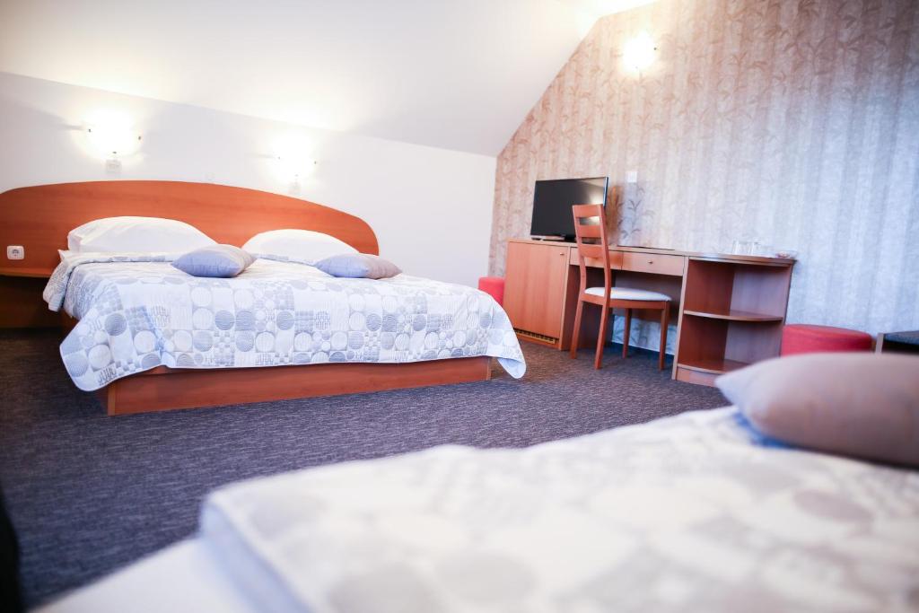 una camera d'albergo con 2 letti e una scrivania di B&B Brezov Gaj a Kranjska Gora