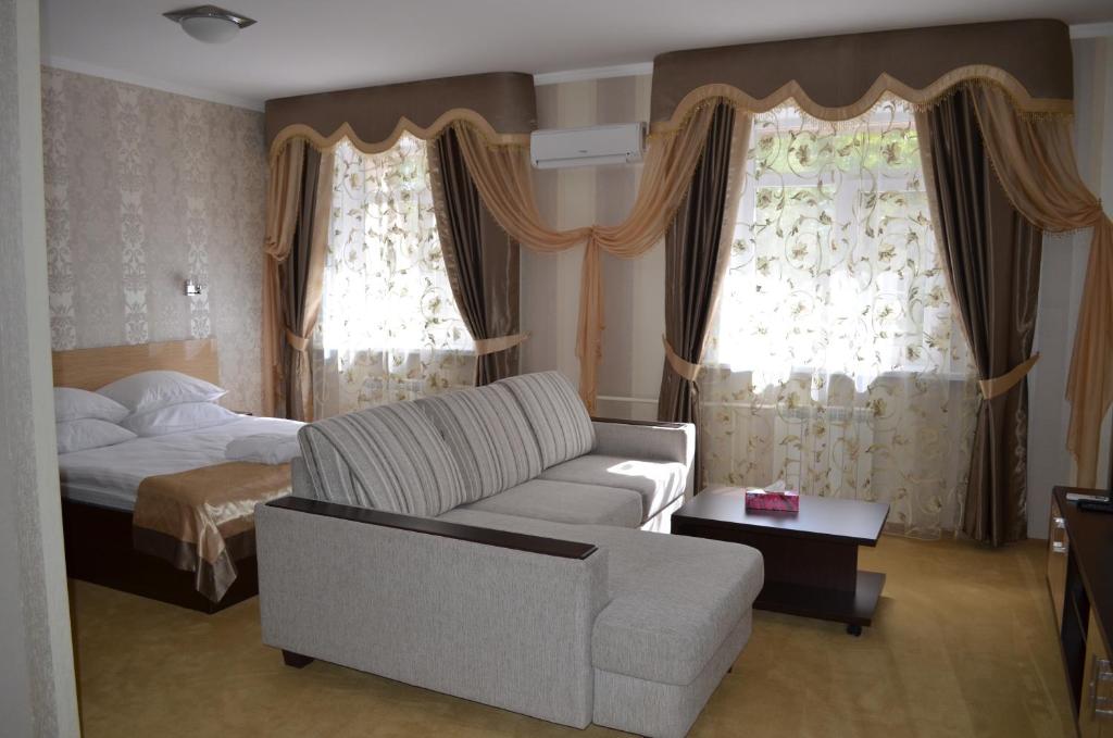 a living room with a couch and a bed at Mereke Hotel in Ustʼ-Kamenogorsk