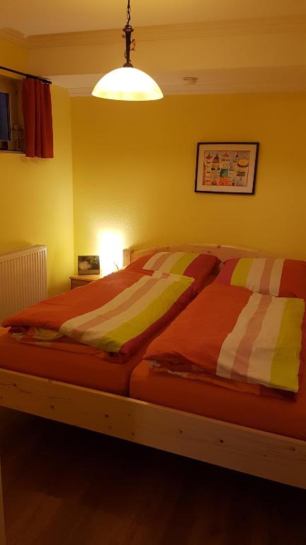 a bedroom with a large bed with striped sheets at Ferienwohnung "Waldeck" Nahe Messe und Bodensee in Friedrichshafen