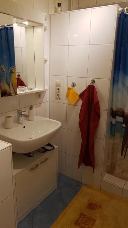 a white bathroom with a sink and a mirror at Ferienwohnung "Waldeck" Nahe Messe und Bodensee in Friedrichshafen