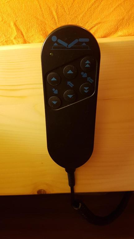 a black remote control hanging on a bed at Ferienwohnung "Waldeck" Nahe Messe und Bodensee in Friedrichshafen