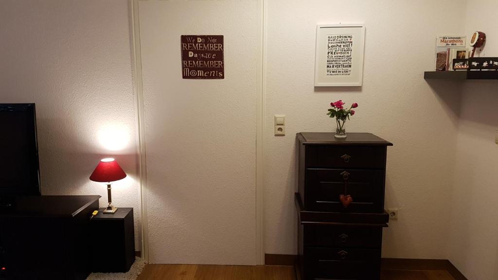 a room with a dresser and a door with a vase of flowers at Ferienwohnung "Waldeck" Nahe Messe und Bodensee in Friedrichshafen