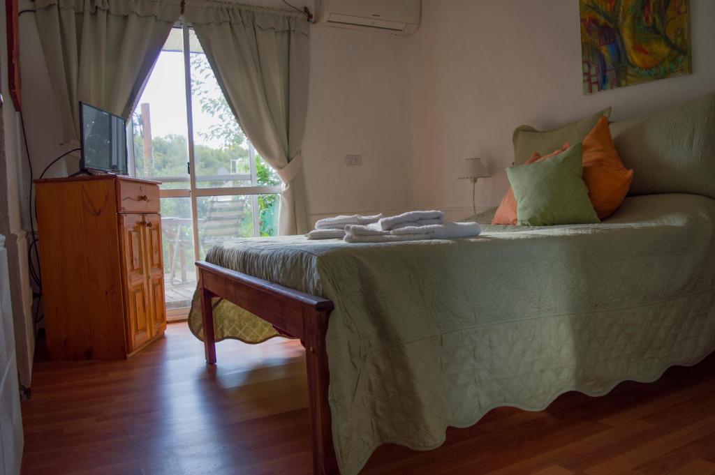 1 dormitorio con 1 cama, TV y ventana en Cabaña Su Estar en Villa Las Rosas