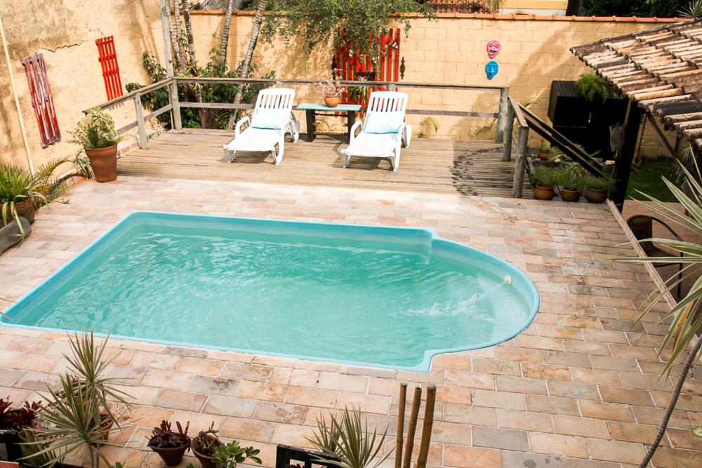 a swimming pool with two chairs and a table at Nino's in Niterói