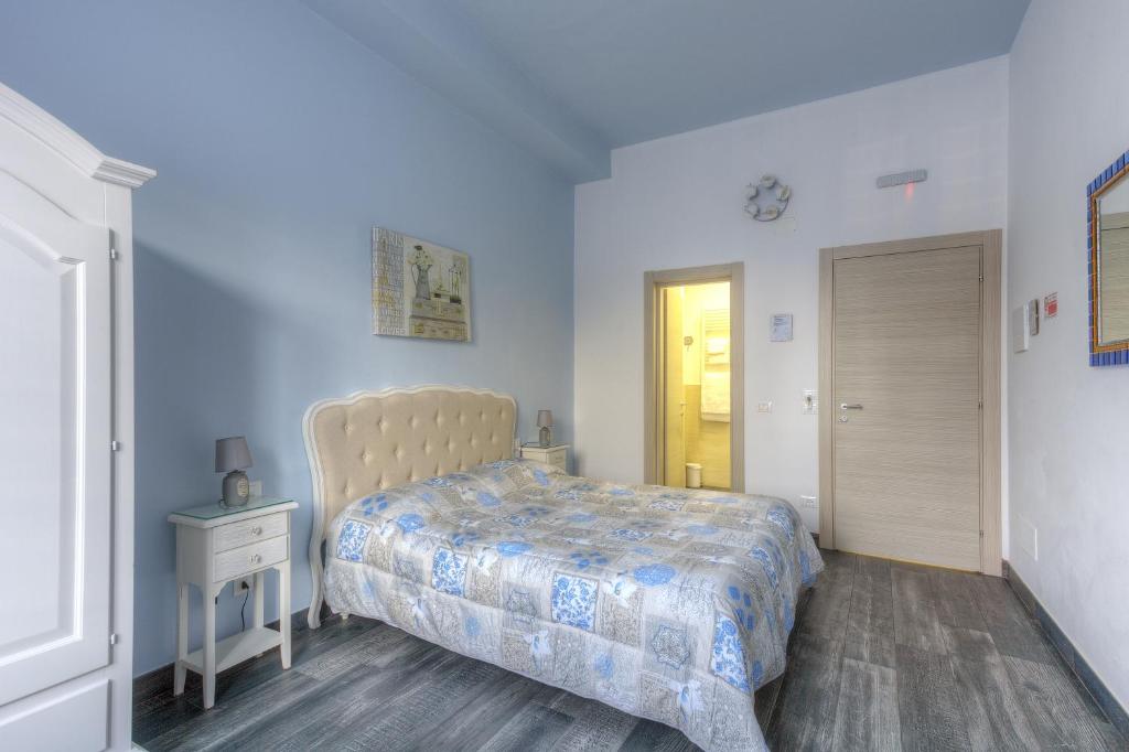 a bedroom with a bed and a night stand and a door at Il Viaggiator Leggero in Florence