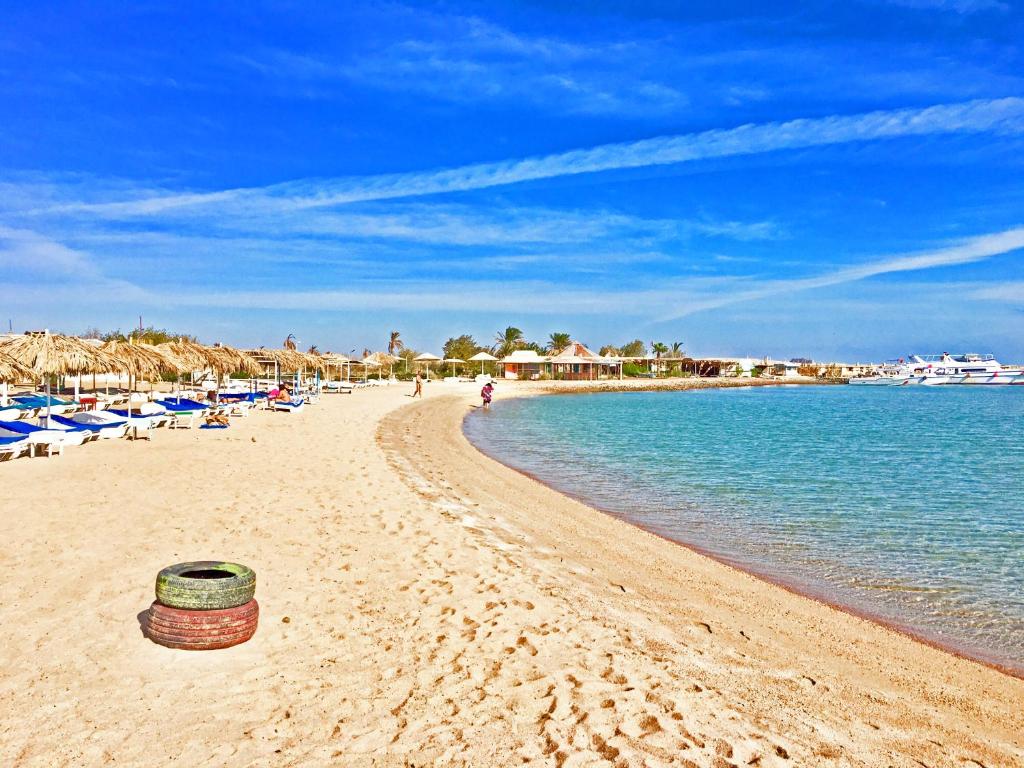 a beach with a basket on the sand and the water at Villages road Suite in Hurghada