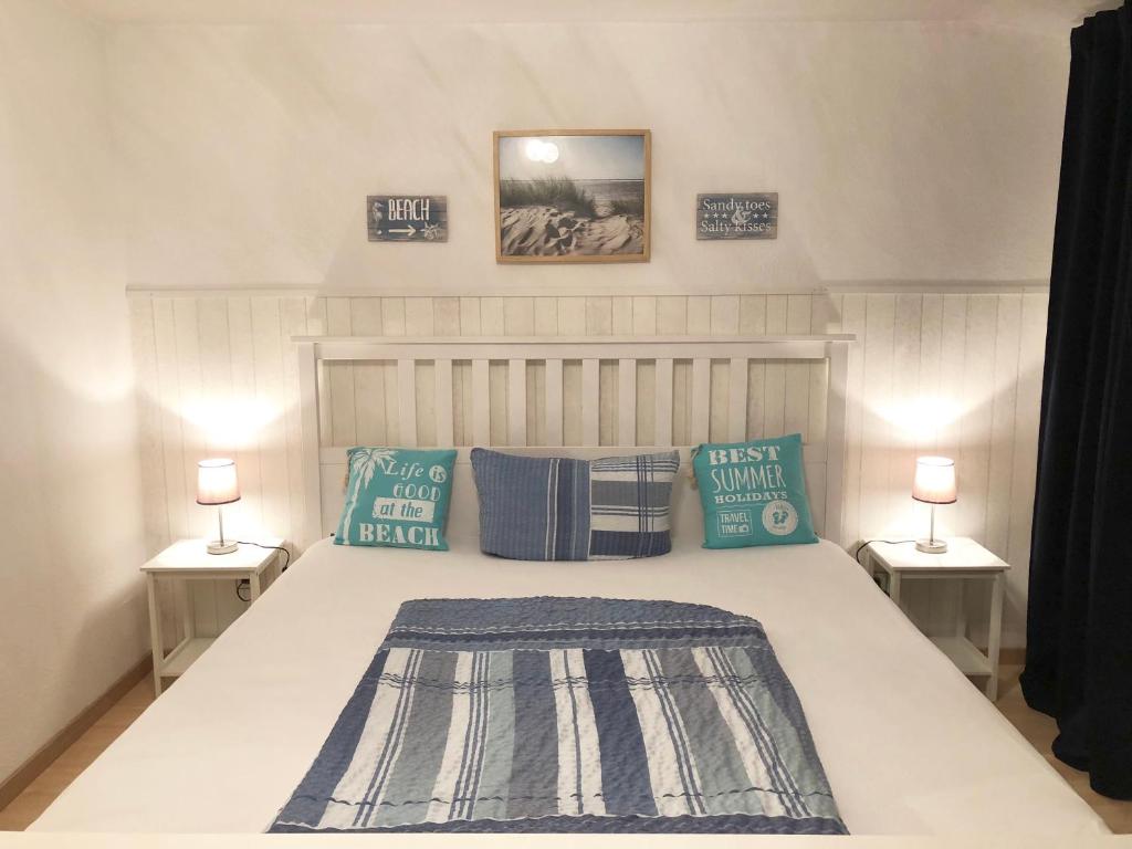 ein Schlafzimmer mit einem Bett mit zwei Lampen an zwei Tischen in der Unterkunft Apartments Zur schönen Aussicht in Büsum