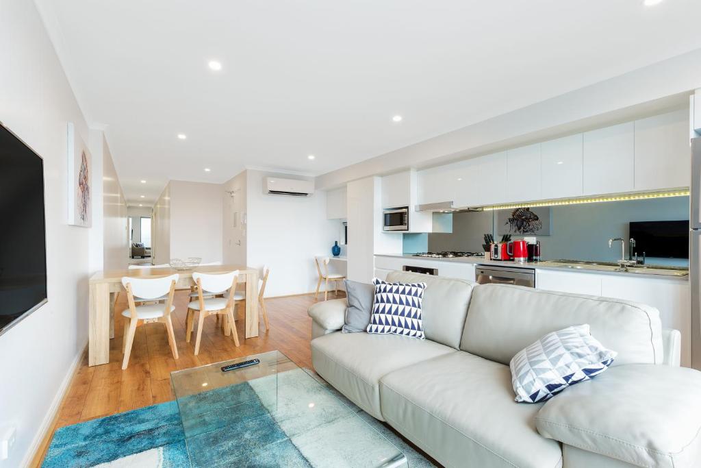 a living room with a couch and a table at Balmain Modern Apartments in Sydney