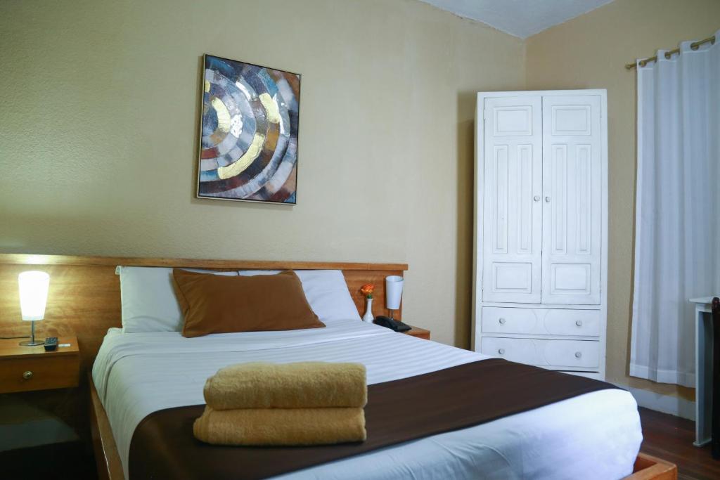 een slaapkamer met een groot bed met een kussen erop bij Hostal Loro Verde in Quito