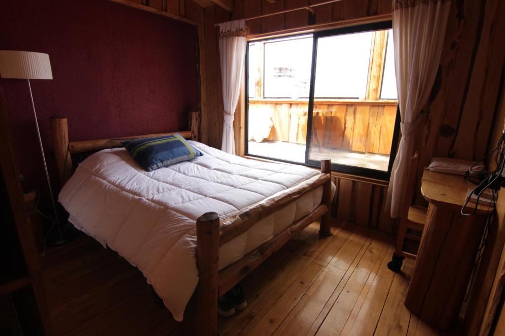 a bedroom with a bed and a window in a room at Hotel Mitos in Quellón