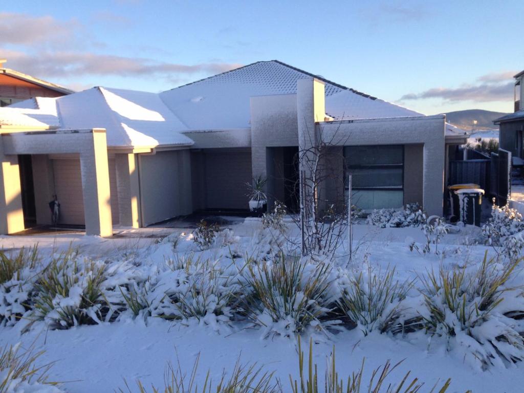 a house with snow on the ground in front of it at Jindabyne Executive in Jindabyne