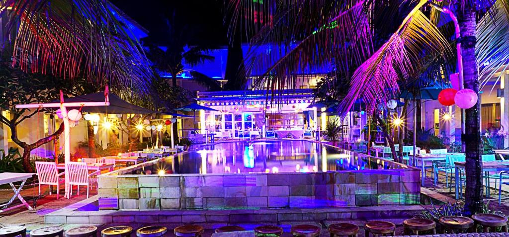 una piscina con tavoli, sedie e luci di Ocean View Residence a Jepara