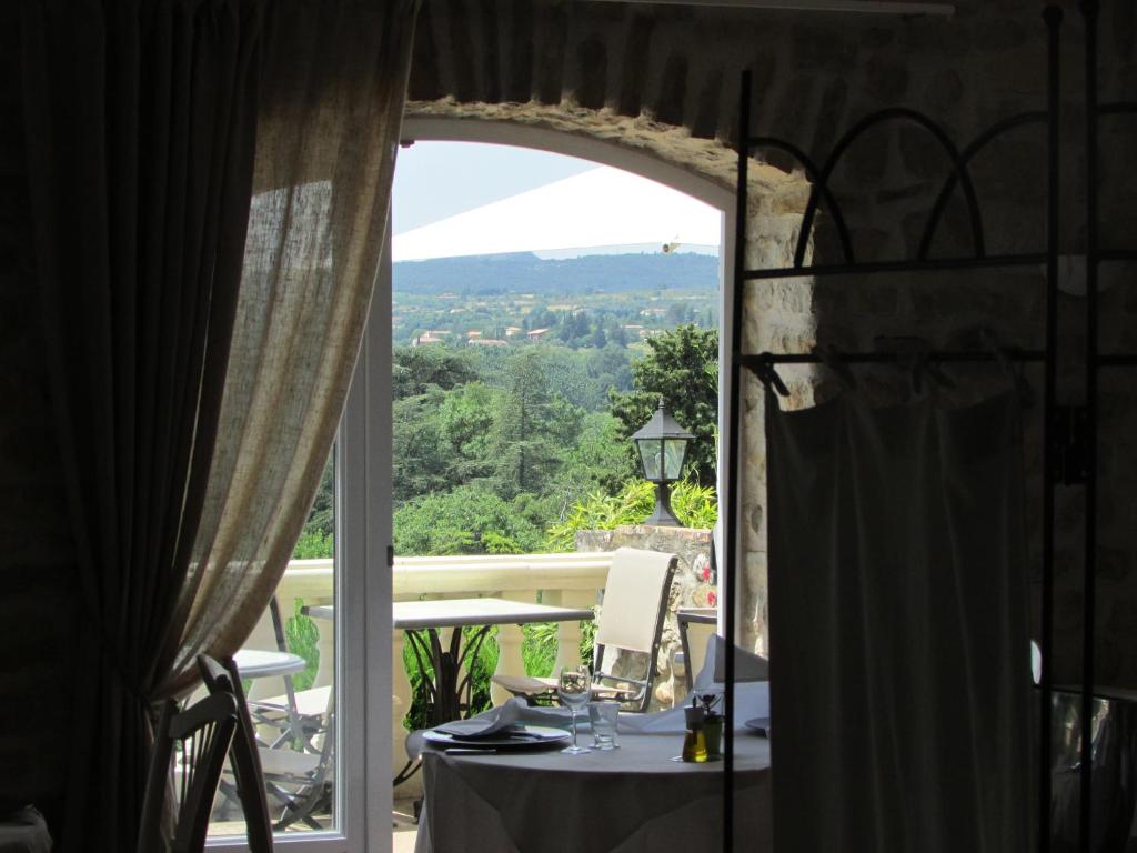 a view from a room with a table and a window at La Bastide Des Senteurs in Saint-Victor-de-Malcap