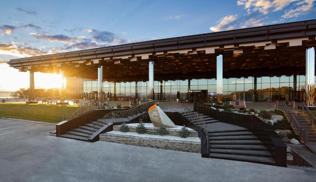 a building with benches and a building with the sun setting at Tigre de Cristal Resort & Casino Vladivostok in Artyom