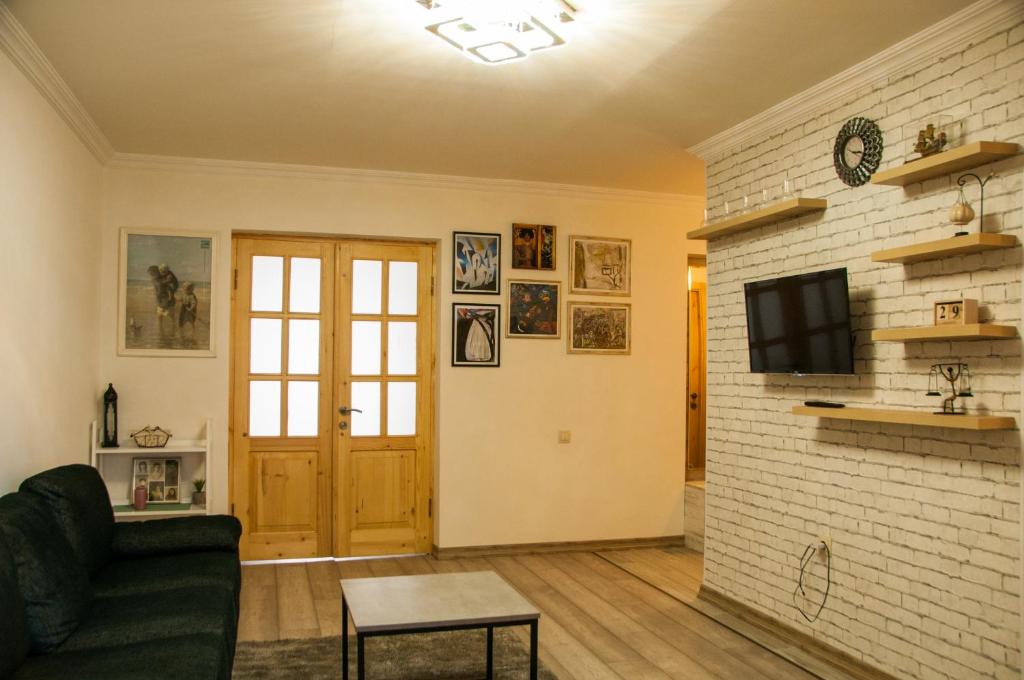 ein Wohnzimmer mit Sofa und Ziegelwand in der Unterkunft Apartment Near Church in Tbilisi City