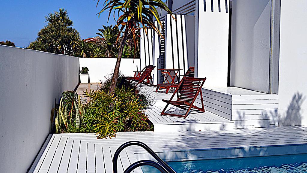 a group of chairs sitting on a porch next to a pool at Beachy Head 61 in Plettenberg Bay