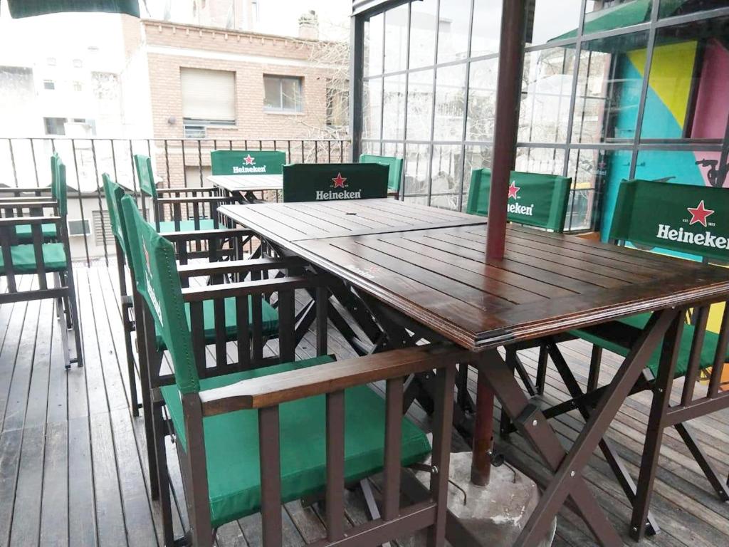 Une table et des chaises en bois sont disponibles sur la terrasse. dans l'établissement Rivera Hostel Córdoba, à Córdoba