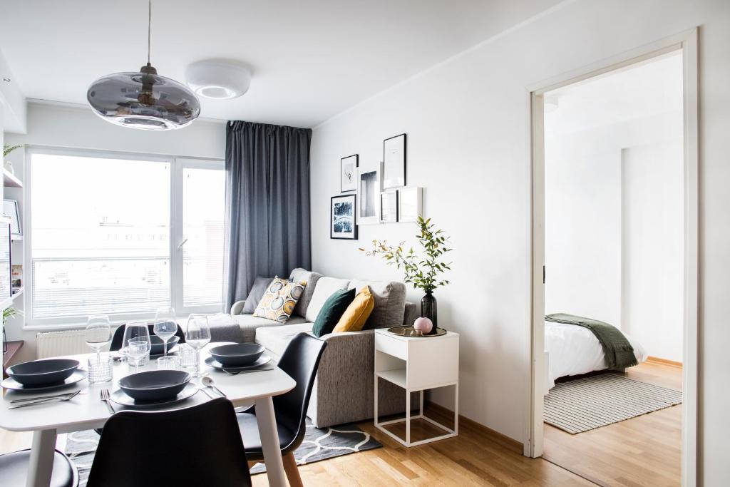 a white living room with a couch and a table at Tallinn Center Jõe Apartment in Tallinn
