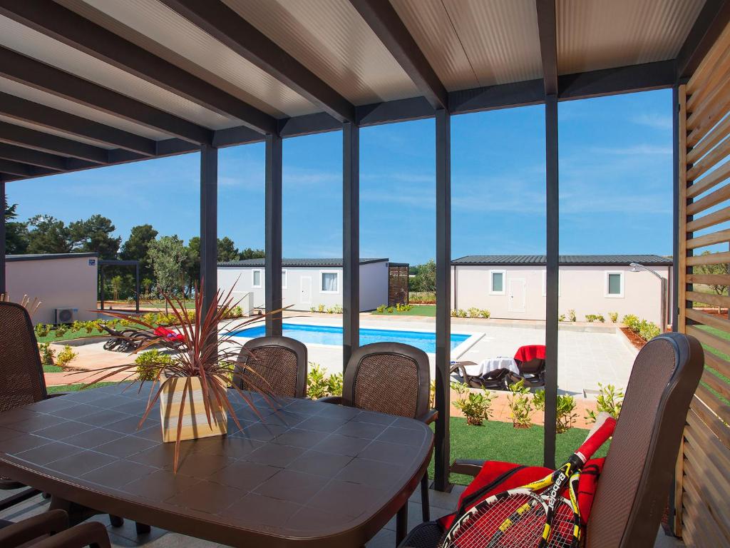 a patio table with chairs and a view of a pool at Superior Mobile Homes in Camping Kastanija in Novigrad Istria