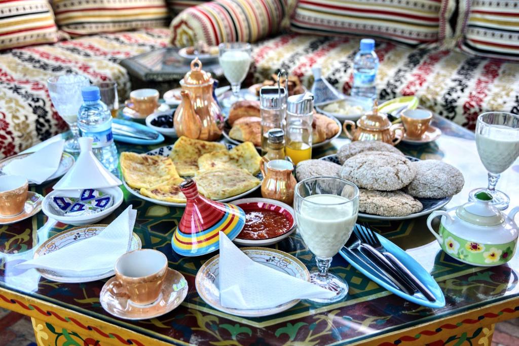 stół pełny jedzenia i napojów na stole w obiekcie Riad Razoli Sidi Fateh w mieście Rabat