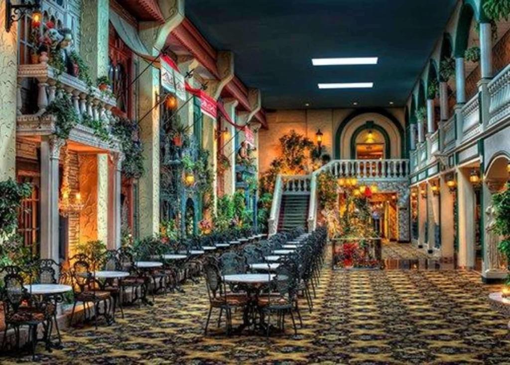 uma sala com mesas e cadeiras num edifício em Garden Place Hotel em Buffalo