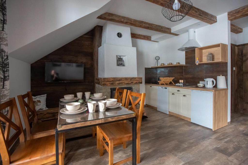 uma cozinha e sala de jantar com mesa e cadeiras em APARTAMENTY ZAZAMCZE em Muszyna