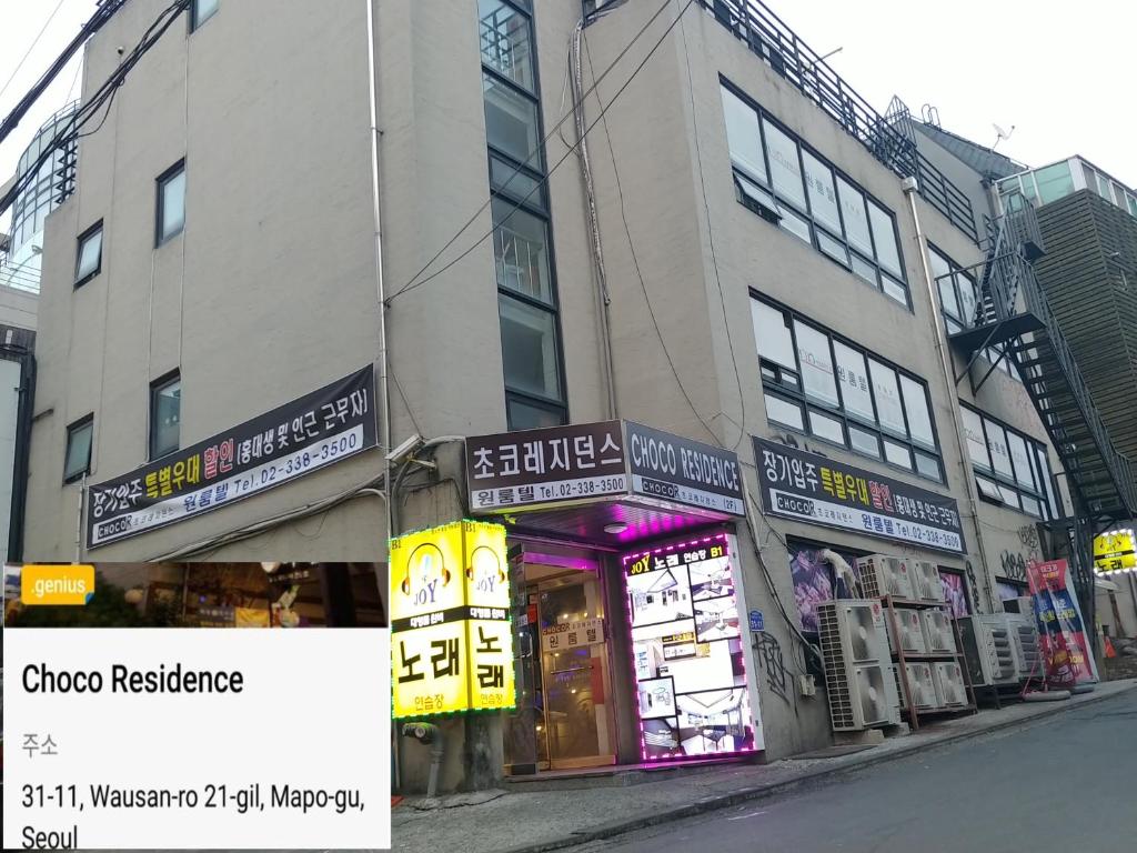 a building with signs on the side of a street at Choco Residence in Seoul