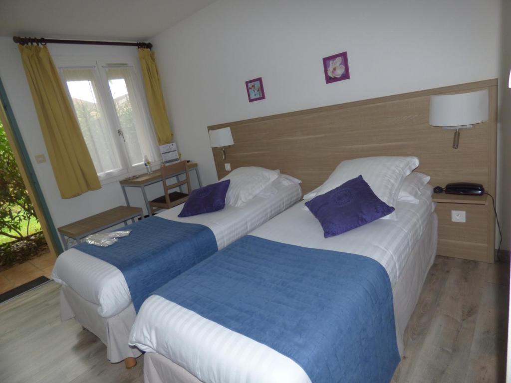 Voodi või voodid majutusasutuse Hôtel Les Comtes de Pardiac toas