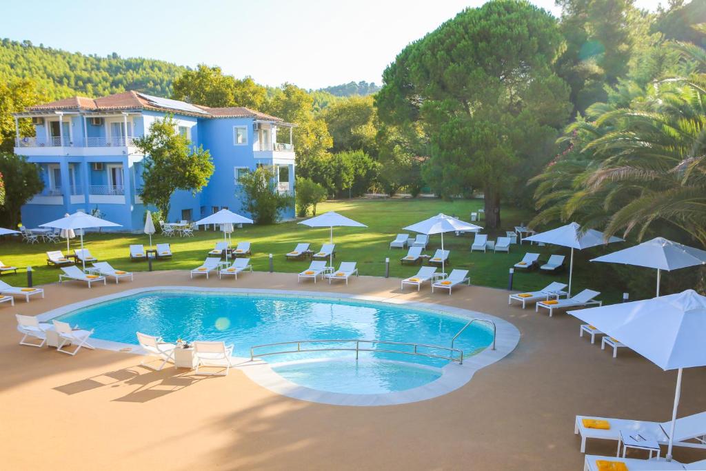an overhead view of a swimming pool with chairs and umbrellas at Mandraki Village Boutique Hotel in Koukounaries