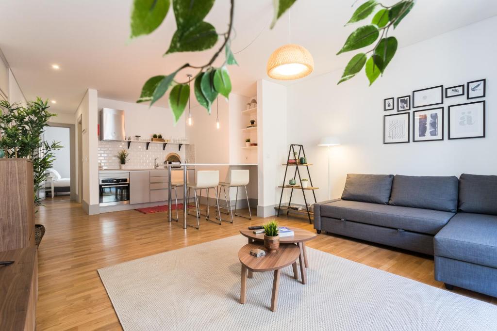 a living room with a blue couch and a table at FLH São Bento Charming Flat in Lisbon