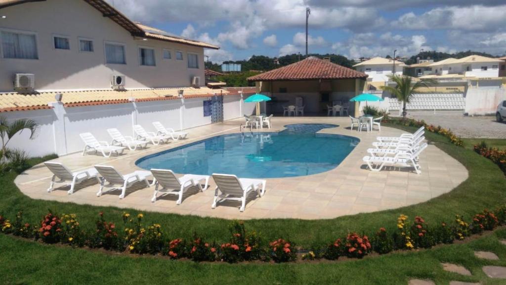 una piscina con tumbonas y una piscina en Residencial Golfinhos, en Porto Seguro