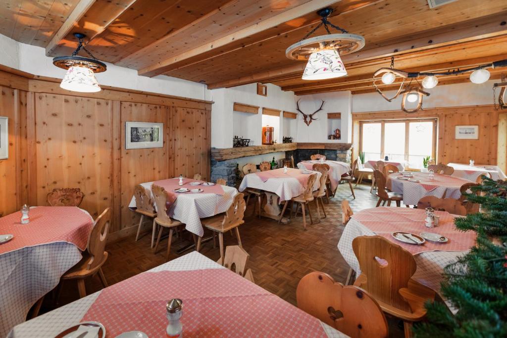 a restaurant with tables and chairs in a room at Hotel Klarer in Zuoz