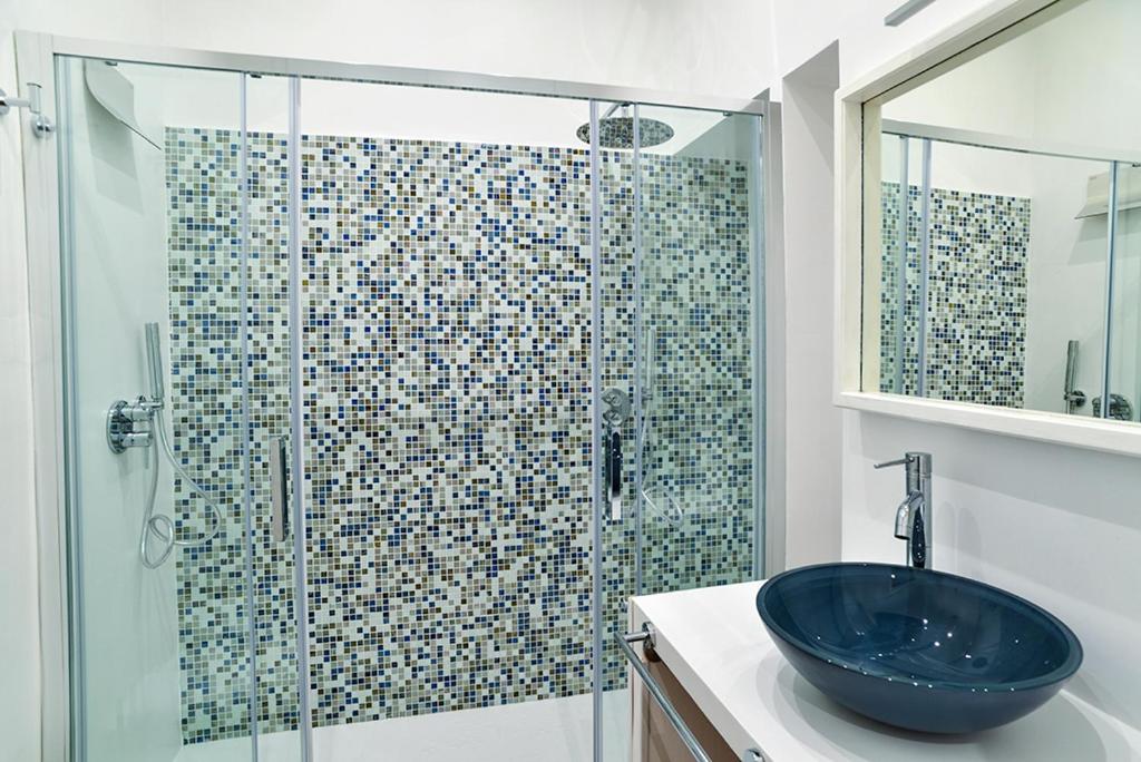 bagno con lavandino e doccia in vetro di the blu and green apartment a Roma