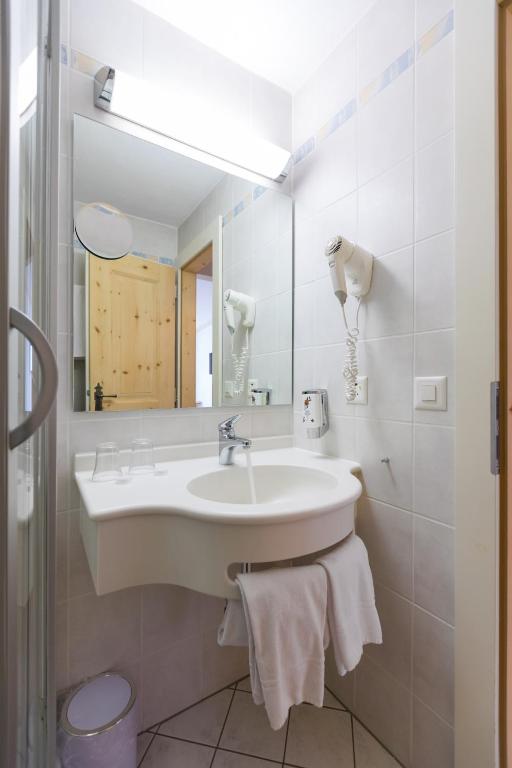 a bathroom with a sink and a mirror at Hotel Klarer in Zuoz