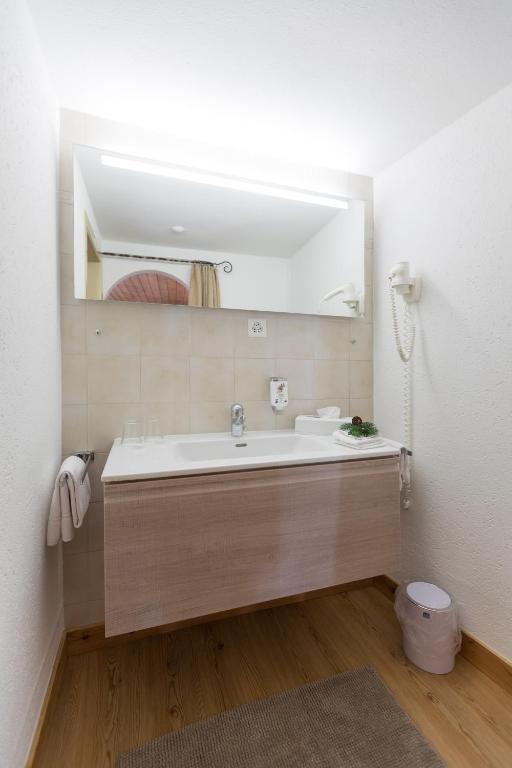 a bathroom with a sink and a mirror at Hotel Klarer in Zuoz