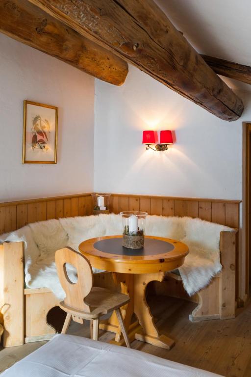 a dining room with a table and a bed at Hotel Klarer in Zuoz