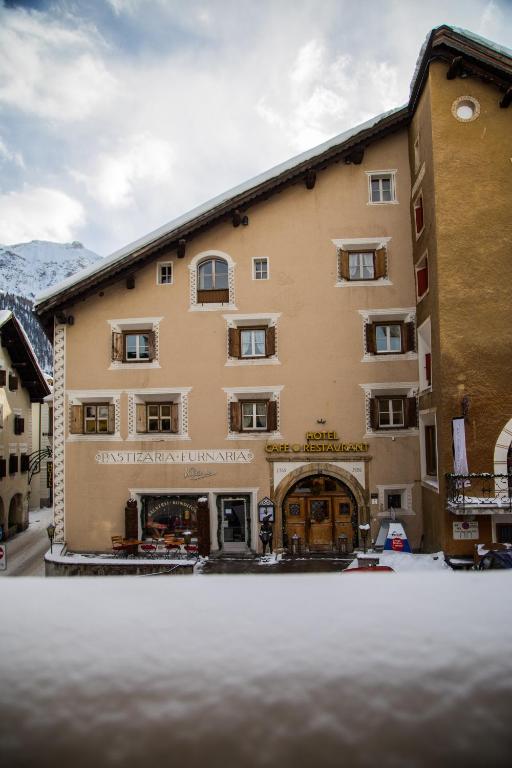 a large building with snow in front of it at Hotel Klarer in Zuoz