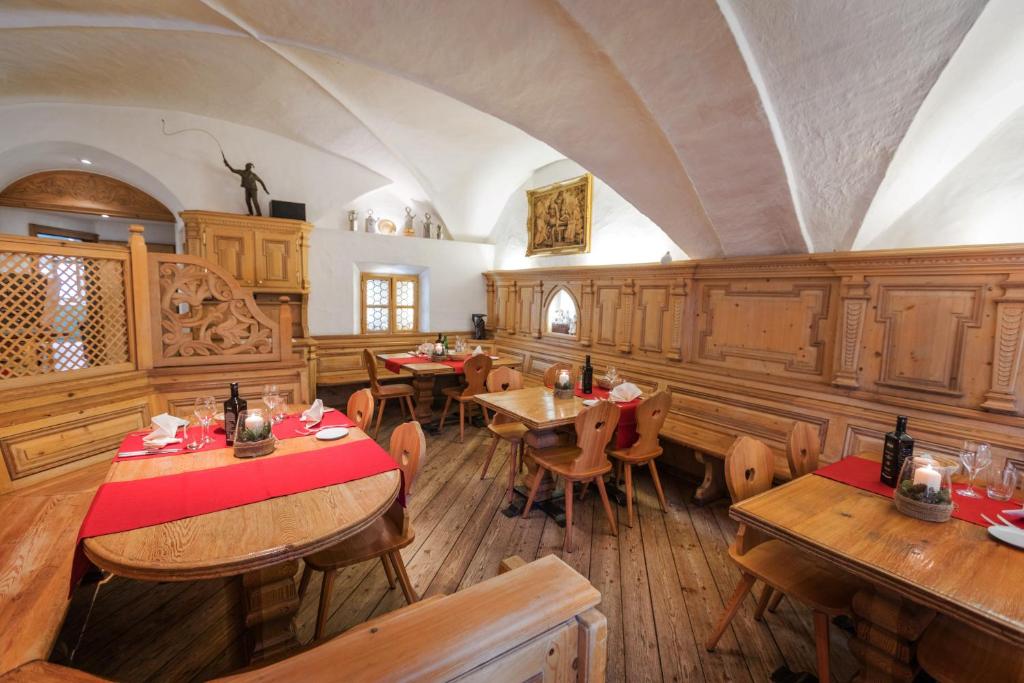 a dining room with wooden tables and chairs at Hotel Klarer in Zuoz