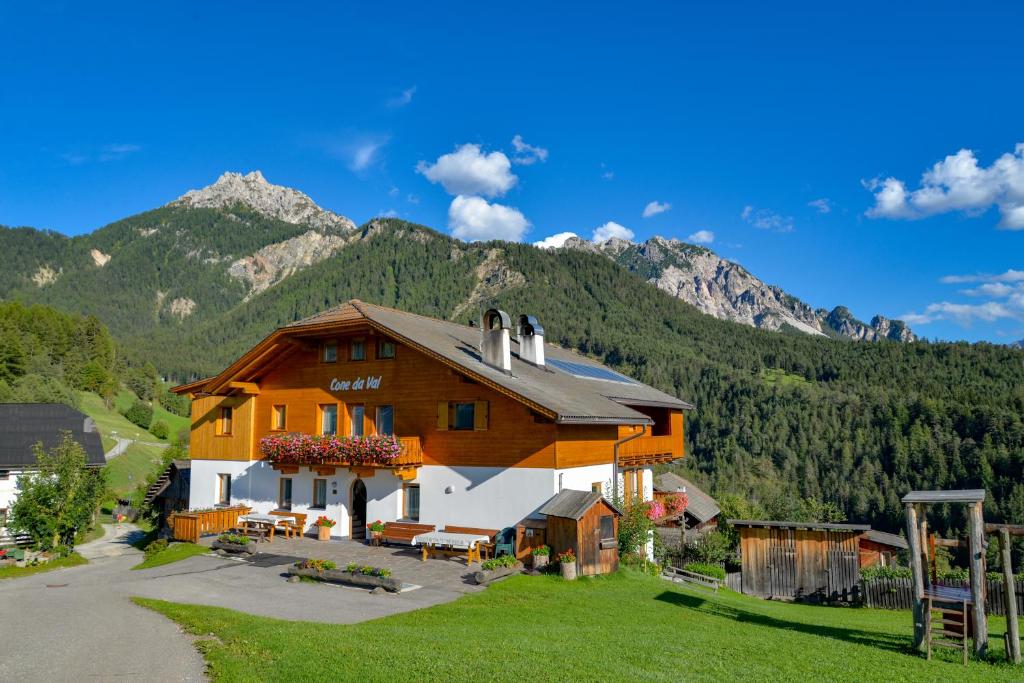 uma casa grande com montanhas ao fundo em Cone da Val em San Vigilio Di Marebbe