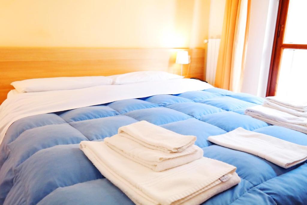 uma cama com lençóis azuis e toalhas em Central Plaza em Lecce