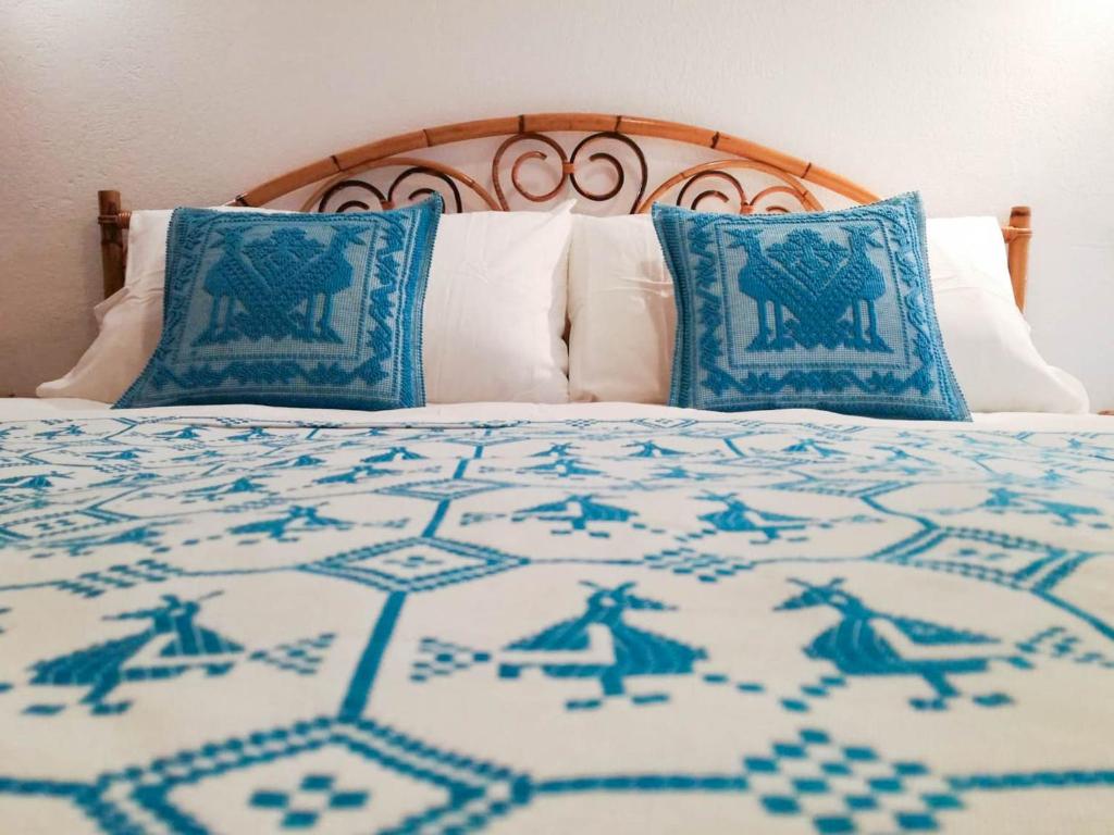 ヴィッラシミーウスにあるVilletta Lantanaのベッド1台(青と白の毛布、枕付)