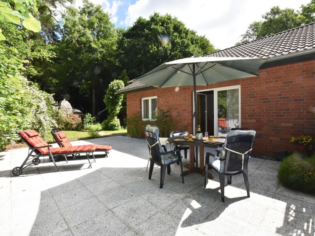 a patio with a table and chairs and an umbrella at Farm holiday home in Damshagen with garden seating and sauna in Klütz