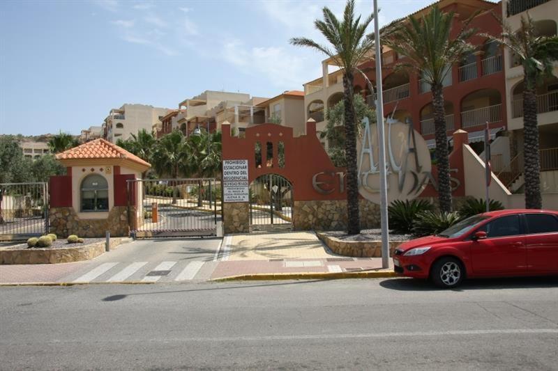 un coche rojo estacionado frente a un edificio en Alta Entinas, en Almerimar