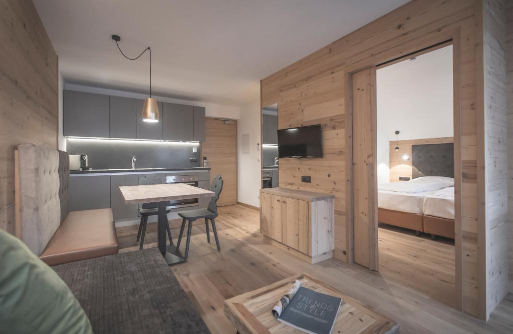 - une chambre avec un lit, un bureau et une table dans l'établissement Ahrner Wirt Apartments, à San Giovanni